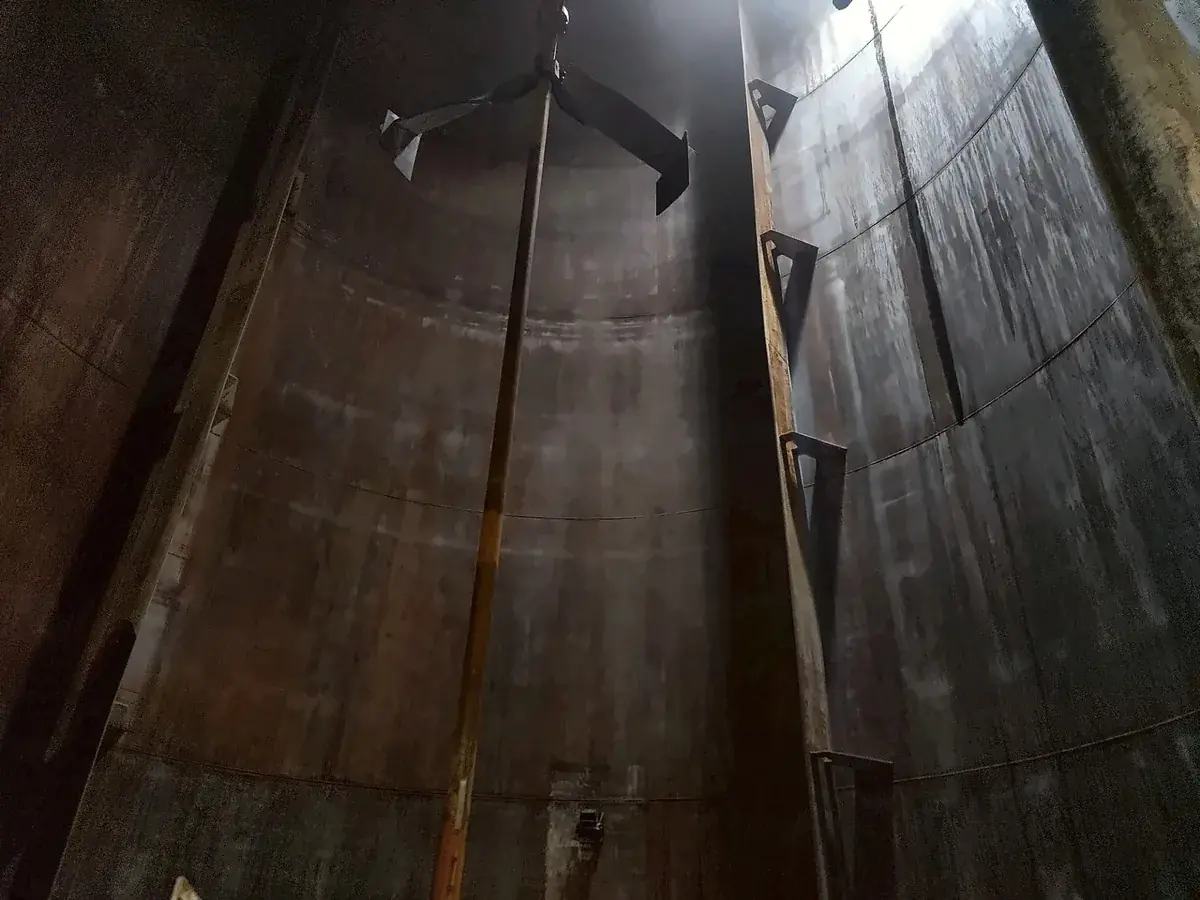 Agitator shaft running the full height of a storage tank up to the roof, with the upper impeller near the top