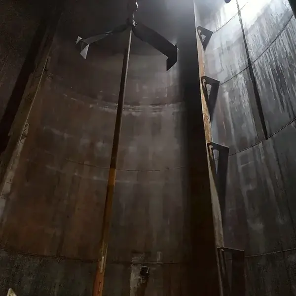 Agitator shaft running the full height of a storage tank up to the roof, with the upper impeller near the top
