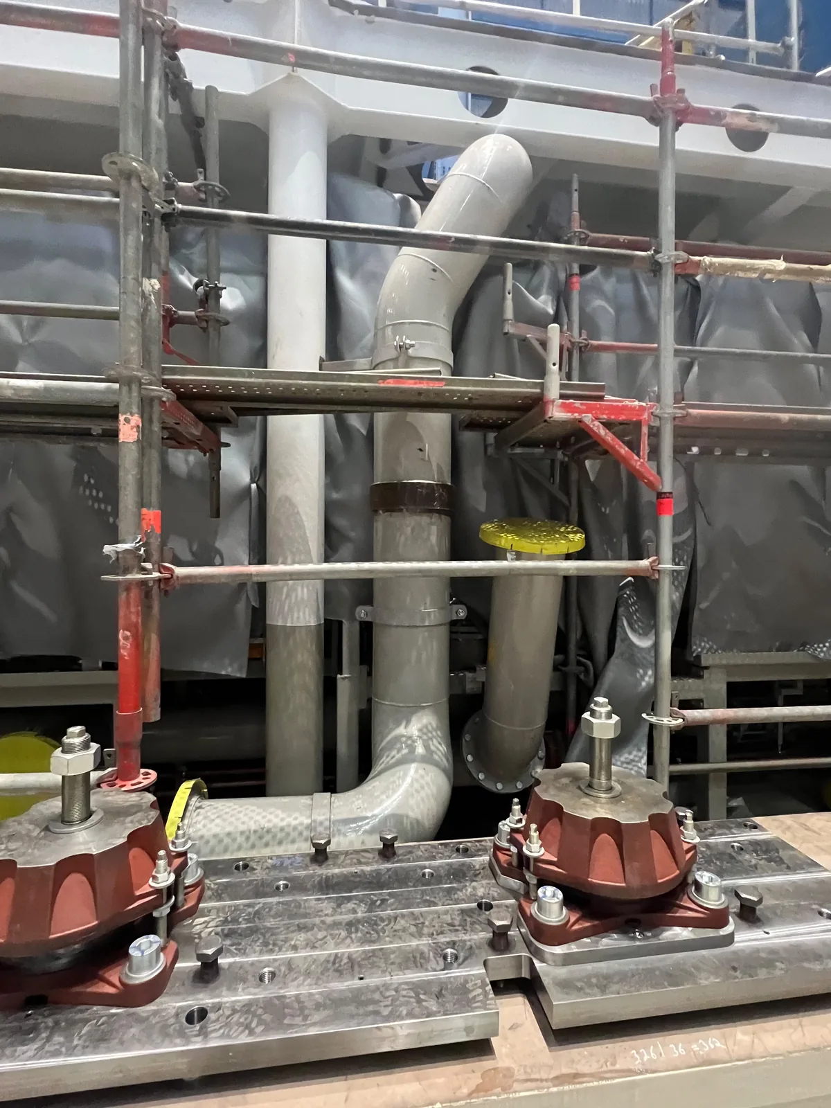 Machined seating in an engine room with resilient mounts bolted down, studs and nuts set, and timber packing alongside