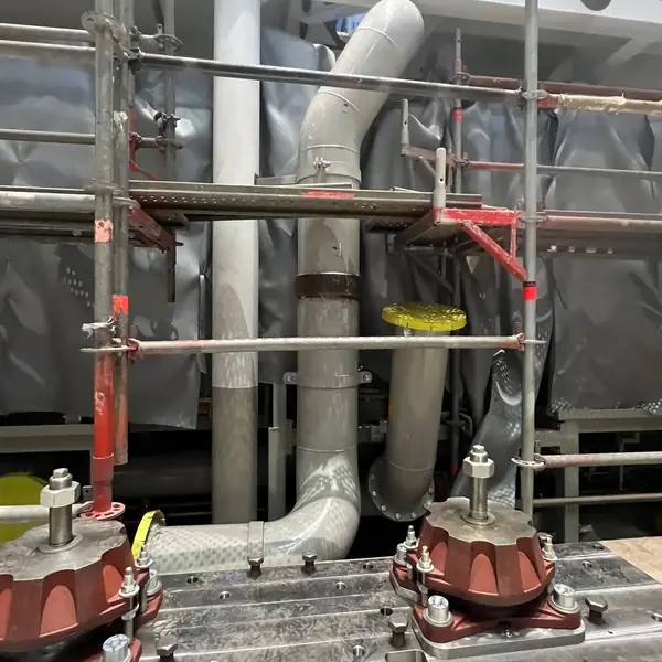 Machined seating in an engine room with resilient mounts bolted down, studs and nuts set, and timber packing alongside