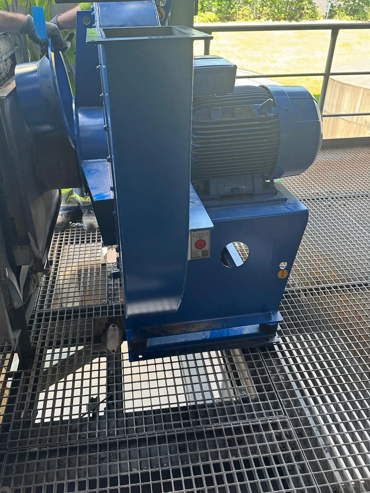 New fan standing on its base with the outlet transition piece offered up under the existing stack
