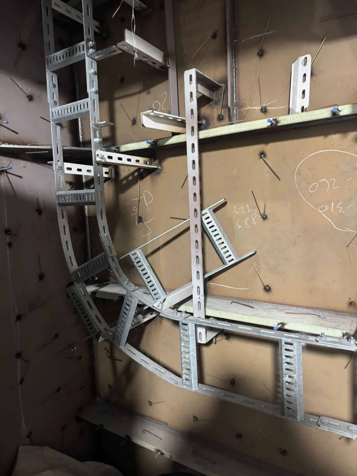 Cable trays and brackets fitted to an insulated bulkhead, with insulation pins welded across the plate