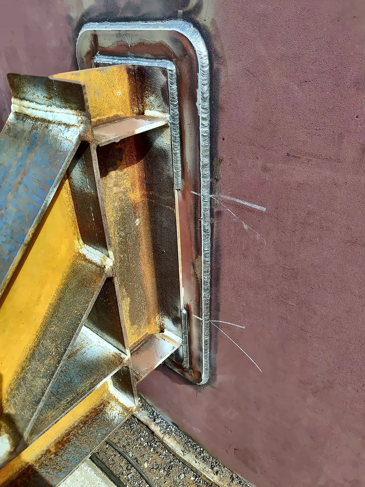 External bracket welded to a pad plate on the tank shell, with the pad welded all round
