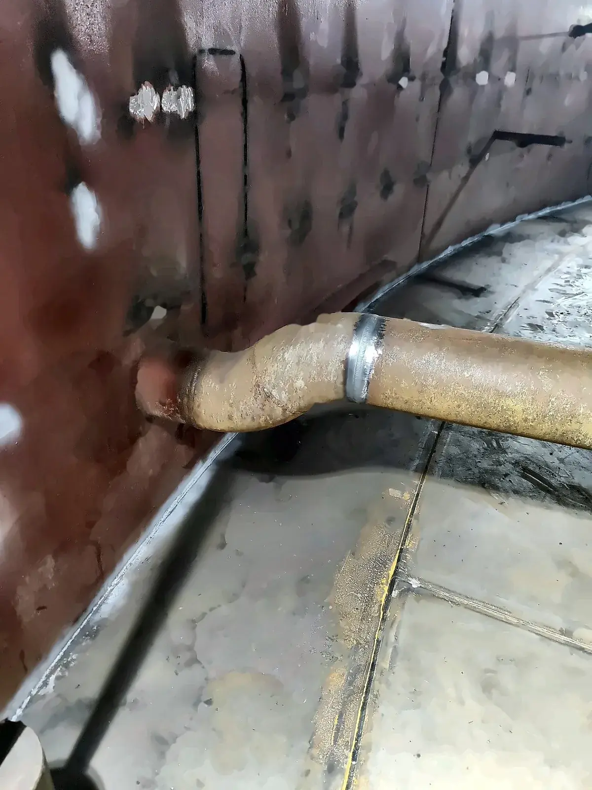 Internal pipe connected to a shell nozzle inside a tank, with bottom plates below