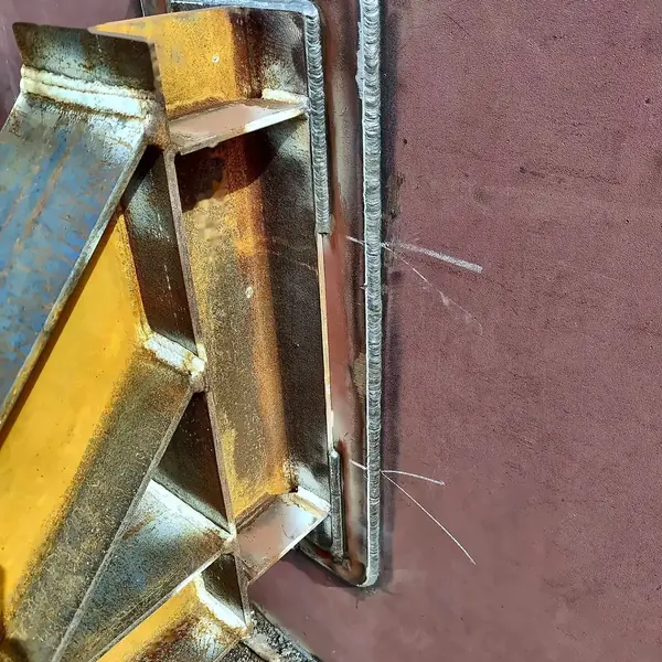 External bracket welded to a pad plate on the tank shell, with the pad welded all round