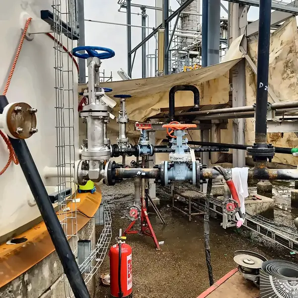 Valve station under temporary cover at the base of a storage tank