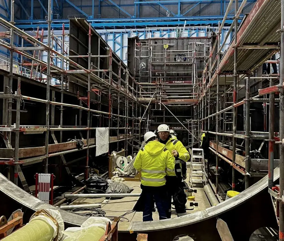 Hull block under construction with fitters working inside the scaffolded section